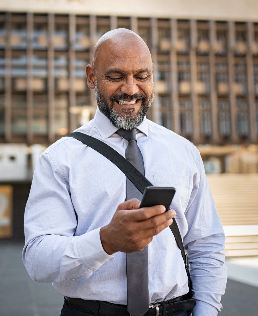 Business man holding cellphone and smiling